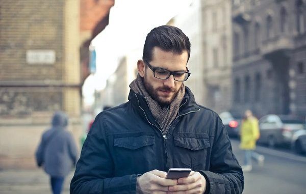 Hombre usando el celular en la calle