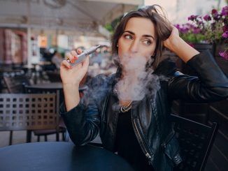 Mujer con cigarro electrónico en la mano