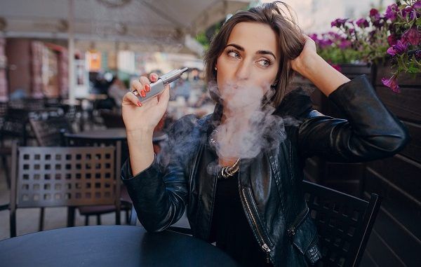 Mujer con cigarro electrónico en la mano